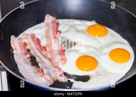 Saporita pancetta strisce giace sulle uova fritte Foto Stock