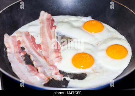 Saporita pancetta strisce giace sulle uova fritte Foto Stock