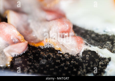 Saporita pancetta strisce giace sulle uova fritte Foto Stock