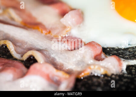 Saporita pancetta strisce giace sulle uova fritte Foto Stock