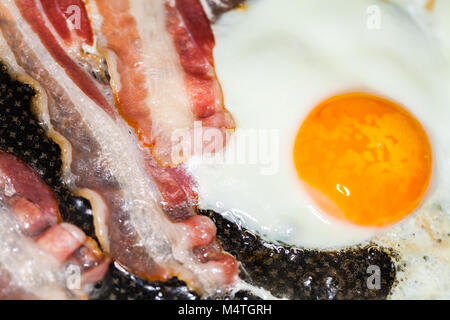 Saporita pancetta strisce giace sulle uova fritte Foto Stock