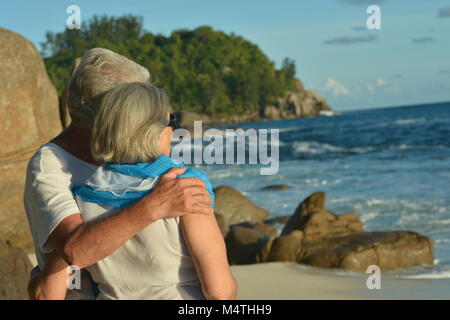 Coppia di anziani in piedi sulla spiaggia sabbiosa Foto Stock