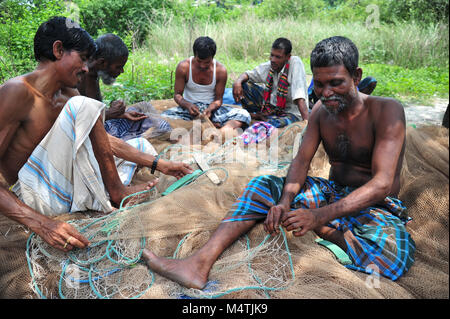 Pescatore del Bangladesh a riparare le reti da pesca in Narayanganj vicino a Dacca in Bangladesh Foto Stock