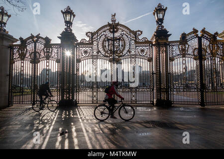 Un ciclista sul suo modo di lavorare al di fuori del Buckingham Palace a Londra Foto Stock