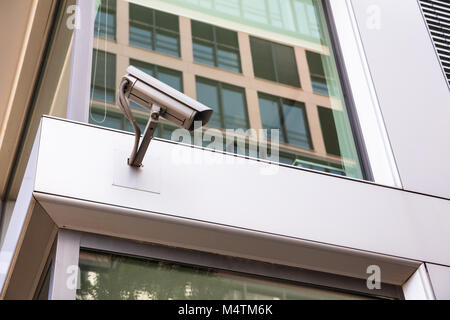 Basso angolo di visione della telecamera di sicurezza montati su edificio per uffici in città Foto Stock