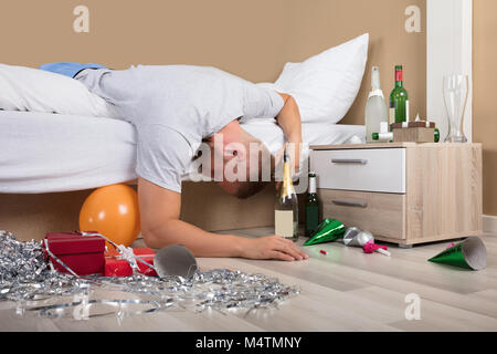 Giovane uomo disteso sul letto con Incasinato piano dopo essere partito Foto Stock