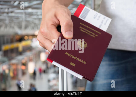 Persona della mano con ritenuta bagagli Passaporto e carta di imbarco biglietti all'aeroporto Foto Stock