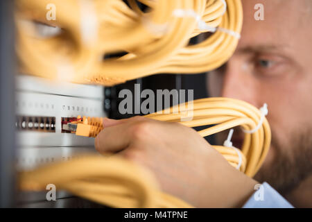 Close-up di ingegnere collegando i cavi nel Server nel centro dati Foto Stock