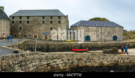 Dinnet Harbour, murene, Scozia, coppie camminando sul molo del porto, aragosta pentole, vecchi edifici in pietra, le barche a remi e a Portsoy edificio in marmo Foto Stock