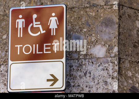 Toilette pubblica segni sul vecchio muro di marmo Foto Stock