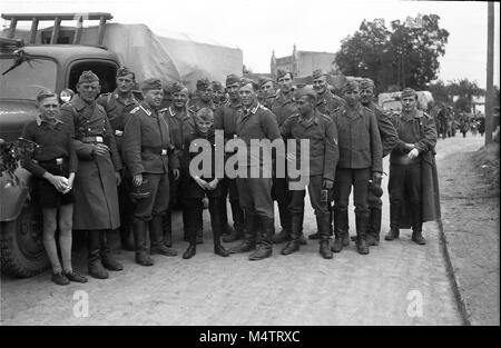 Esercito Tedesco soldati con giovani ragazzi della Gioventù Hitleriana come si preparano a partire per la Francia nella prima parte della seconda guerra mondiale Foto Stock