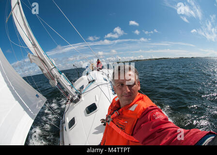 Barca a vela in arcipelago finlandese / Nord Europa, scoprendo isole segrete. Due marinai su un sportivo francese Beneteau barca a vela Foto Stock