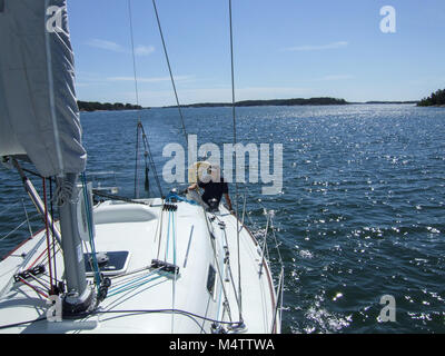 Barca a vela in Finnland, l'arcipelago finlandese / Nord Europa, scoprendo isole segrete. Sailor su un sportivo francese Beneteau barca a vela Foto Stock