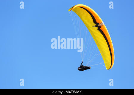 Sky Diver con giallo arancione parachute galleggianti in aria Foto Stock