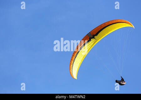 Sky Diver con giallo arancione parachute galleggianti in aria Foto Stock