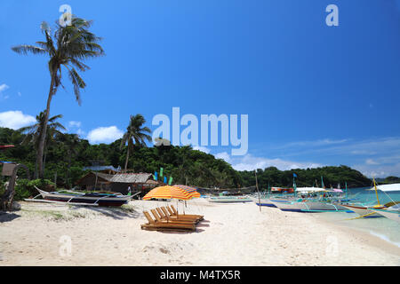 Barche di pescatori locali di bambù e lettini per prendere il sole sul Ilig Iligan beach, Boracay Island, Filippine Foto Stock