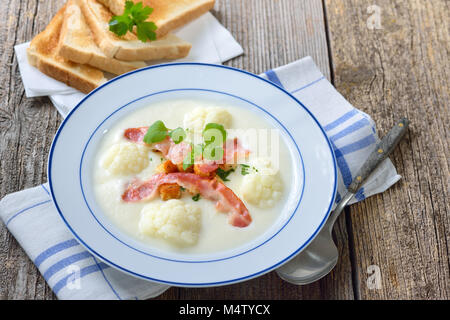 Deliziosa crema di cavolfiore Zuppa guarnita con pancetta fritta e crostoni di pane fresco, servito con toast croccanti Foto Stock