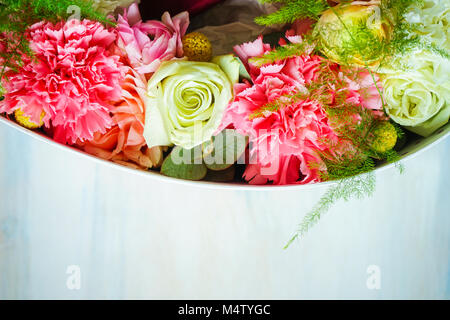 A forma di cuore scatola regalo pieno di fiori di anemone su sfondo scuro con spazio di copia Foto Stock