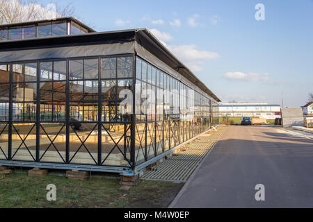 Una serra edificio nei pressi di un giardino dalla mostra orticola Foto Stock