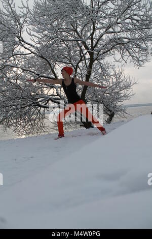 Flessibile bella giovane donna fatto mattina yoga pone nella fredda giornata invernale Foto Stock