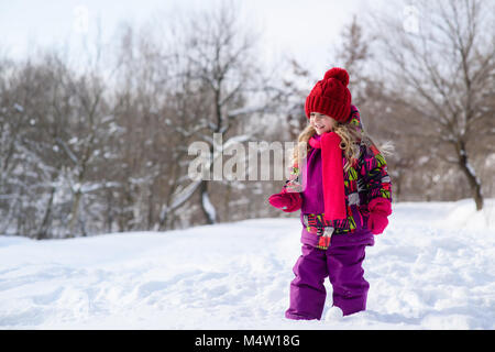 Poco carino bambina su uno sfondo innevato Foto Stock