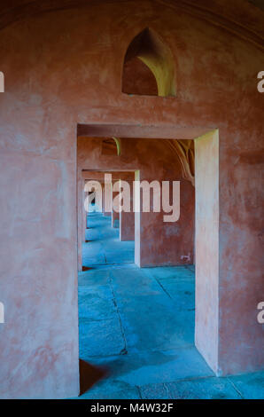 Color Terracotta porta rettangolare modello ripetitivo sormontato da keyhole appuntita windows in Agra, India. Foto Stock