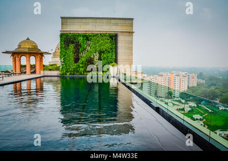 Svuotare infinity pool sul tetto a terrazza che si affaccia su New Delhi, India. In vetro trasparente di scherma piscina protegge dal bordo del tetto alto sopra di New Delhi, India city Foto Stock