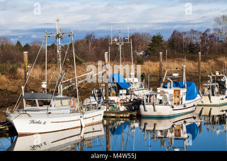 Commerciale di pesca barche ormeggiate in un canale narow a Steveston, British Columbia Foto Stock