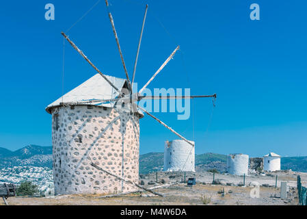 Fila di restaurato tradizionali mulini a vento sulla cima della collina di Bodrum affacciato Bodrum e Gumbet. Foto Stock