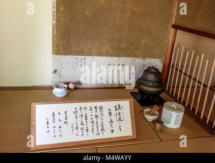 Close-up di giapponese tradizionale stile sōan teahouse. Utensili di tè, partizione di bambù, tè frusta, metallo del riscaldatore di acqua, segno con la scrittura giapponese. Foto Stock