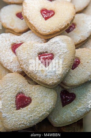 A forma di cuore con biscotti a forma di cuore ad jam-riempito con foro centrale Foto Stock