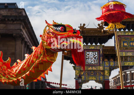 La tradizionale danza del drago catturato nella parte anteriore del paifang in Liverpool il quartiere Chinatown nel febbraio 2018 durante il Festival della Primavera Cinese. Foto Stock