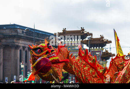 La tradizionale danza del drago catturato nella parte anteriore del paifang in Liverpool il quartiere Chinatown nel febbraio 2018 durante il Festival della Primavera Cinese. Foto Stock