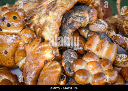 Deliziosi panini dolci cotti in varie forme e cosparso di semi di papavero e altre spezie. Foto Stock