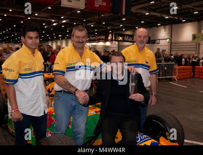 Nigel Mansell CBE, circondato da Benetton F1 Team Meccanica, posa con la London Classic Car Show 'icona' Award nella Grand Avenue, dopo il suo drive in Benetton 193B F1 auto Foto Stock