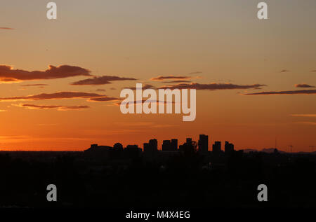 Phoenix, AZ, Stati Uniti d'America. 18 Febbraio, 2018. Febbraio 18, 2018- Phoenix, AZ, Stati Uniti d'America - Il sole tramonta dietro il centro di Phoenix nel febbraio 18, 2018. Credito: KC Alfred/ZUMA filo/Alamy Live News Foto Stock