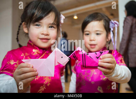 Toronto, Canada. 18 Febbraio, 2018. Due ragazze in posa per le foto con la loro piegatura della carta cani durante il 2018 Toronto Felice Anno Nuovo Cinese Reception & Family Day Weekend evento presso il Royal Ontario Museum(rm) a Toronto in Canada, Feb 18, 2018. Con il cinese papercut, calligrafia, danza del leone e più, questa annuale per il nuovo anno cinese evento ha dato dei calci a fuori la domenica per attirare centinaia di visitatori per celebrare il nuovo anno lunare cinese del cane al Royal Ontario Museum di Toronto. Credito: Zou Zheng/Xinhua/Alamy Live News Foto Stock