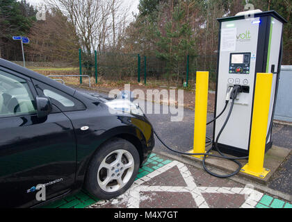 Una Nissan Leaf auto elettrica utilizzando un tri-caricabatteria rapido a un veicolo elettrico stazione di carica, Riccarton, Edimburgo. Foto Stock