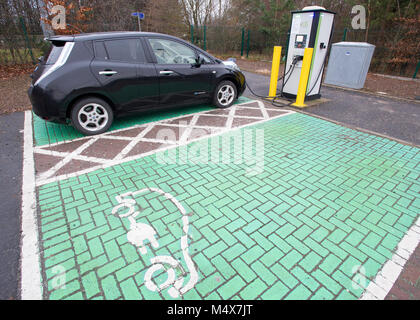 Una Nissan Leaf auto elettrica utilizzando un tri-caricabatteria rapido a un veicolo elettrico stazione di carica, Riccarton, Edimburgo. Foto Stock