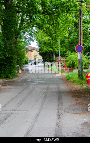 Strada che conduce a colonia di alloggiamento attraverso lussureggianti coperchio in Prévessin-Moëns, Francia Foto Stock