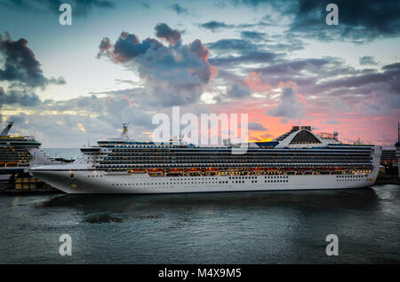 Magnifico tramonto arancione sullo sfondo dietro la nave di crociera nei Caraibi. Foto Stock