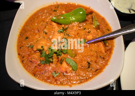 Achar pollo al curry servita con peperoncino verde in una ciotola in un ristorante indiano Foto Stock