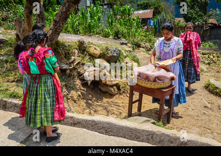 La scuola dei bambini in una scuola rurale in Guatemala raccogliere monete per acquistare il pranzo da un venditore ambulante. Foto Stock