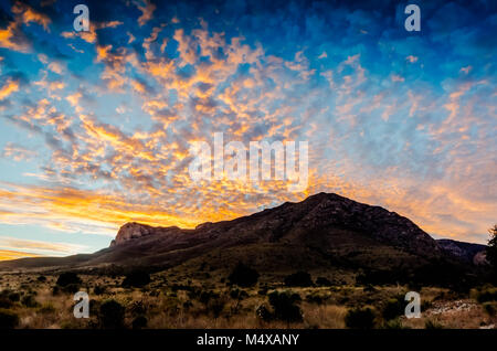 Fine del tramonto dipinge un tocco di oro su cloudscape sopra El Capitan picco a Guadalupe Mountain National Park in Texas. Foto Stock