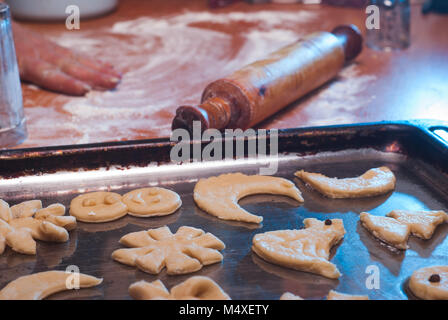 L'impasto è pronto per la cottura dei biscotti di Natale, le mani si diffondono l'impasto su una teglia da forno e cuocere Foto Stock