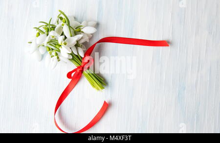 Snowdrops fresco bouquet su uno sfondo di legno Foto Stock