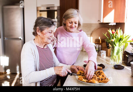 Due donne senior di preparare il cibo in cucina. Famiglia e generazioni concetto. Foto Stock