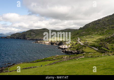 Una stretta strada costiera, parte del Ring of Beara nell'Irlanda del Sud, di fronte alla baia di Kenmare tra Allihies e Eyeries sulla penisola di Beara. Il Foto Stock