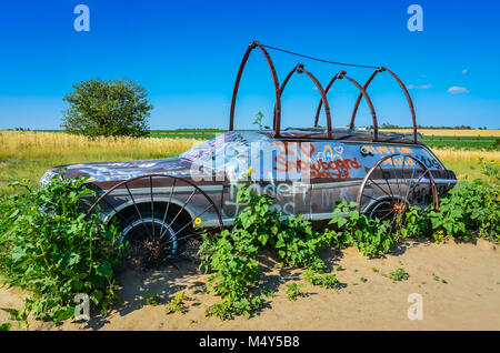 Stazione di solista carro coperto in ruote di carri trellis moduli per le piante. Si trova accanto alla scultura all'aperto del dipinto di grigio automobili, disposti a guardare come Stoneh Foto Stock