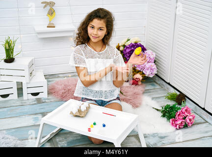 Ragazza ispanica decora le uova Foto Stock